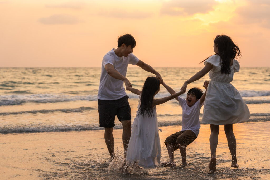 About asian young happy family enjoy vacation on beach in the evening.